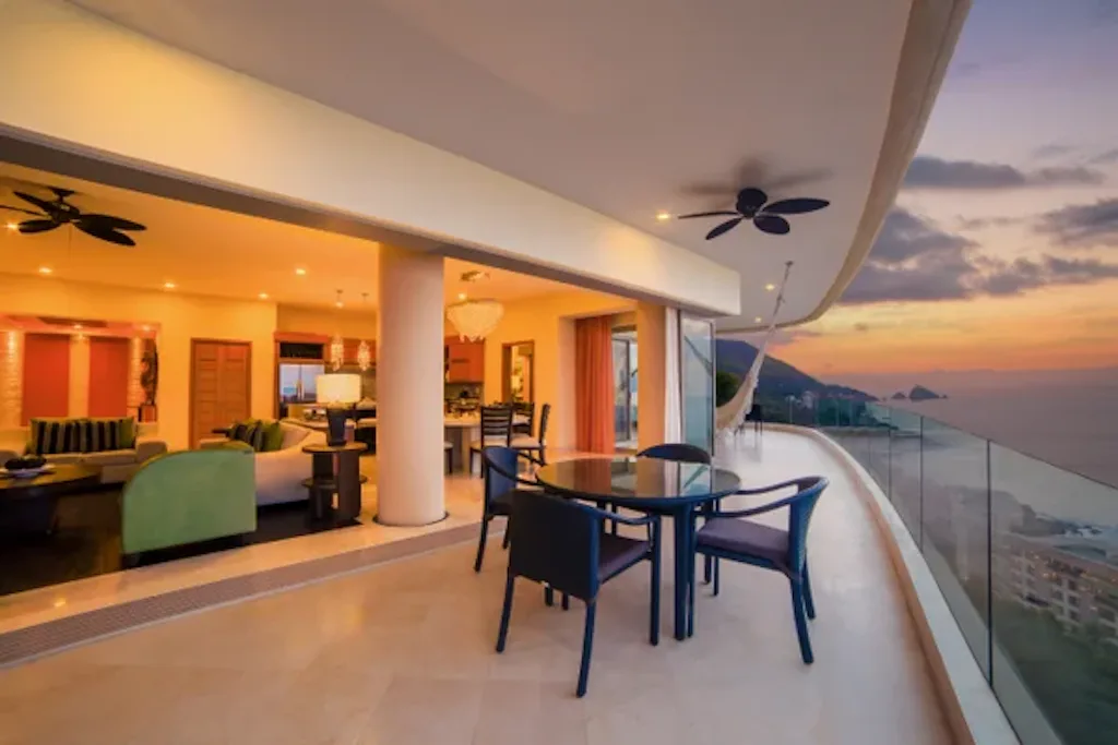 Wraparound terrace at sunset with bay views and the open living room
